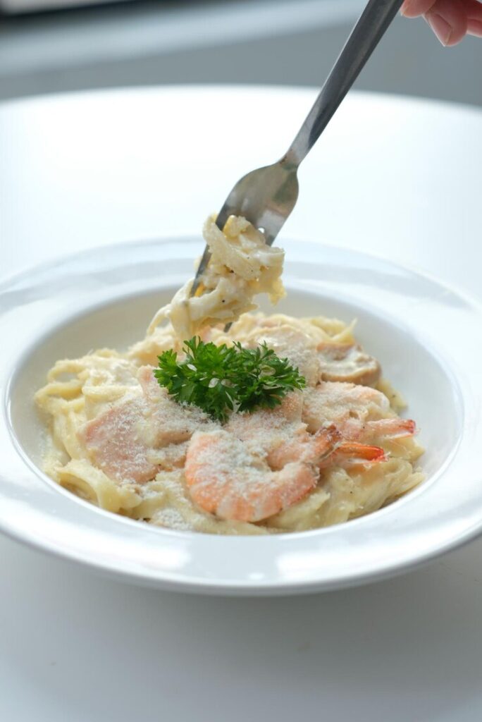 tep-by-step Instant Pot Chicken Alfredo preparation from sautéing to stirring