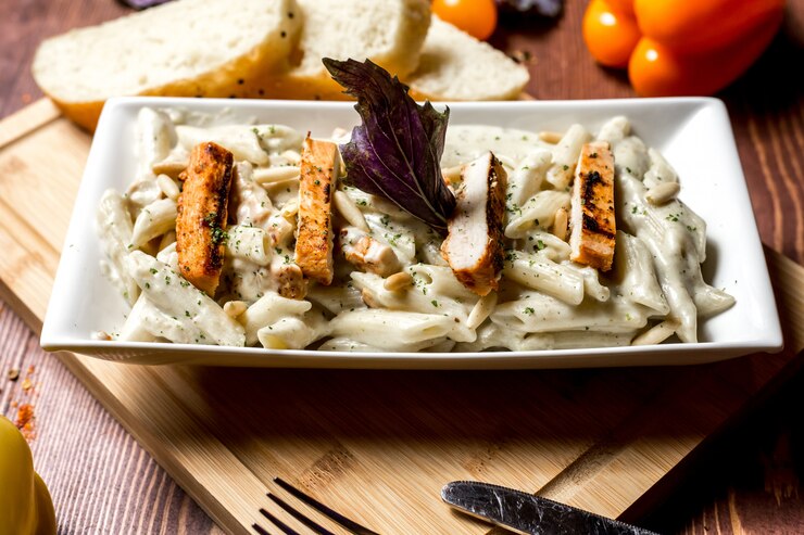 Chicken Alfredo pasta with parmesan and garlic bread in cozy dinner setting